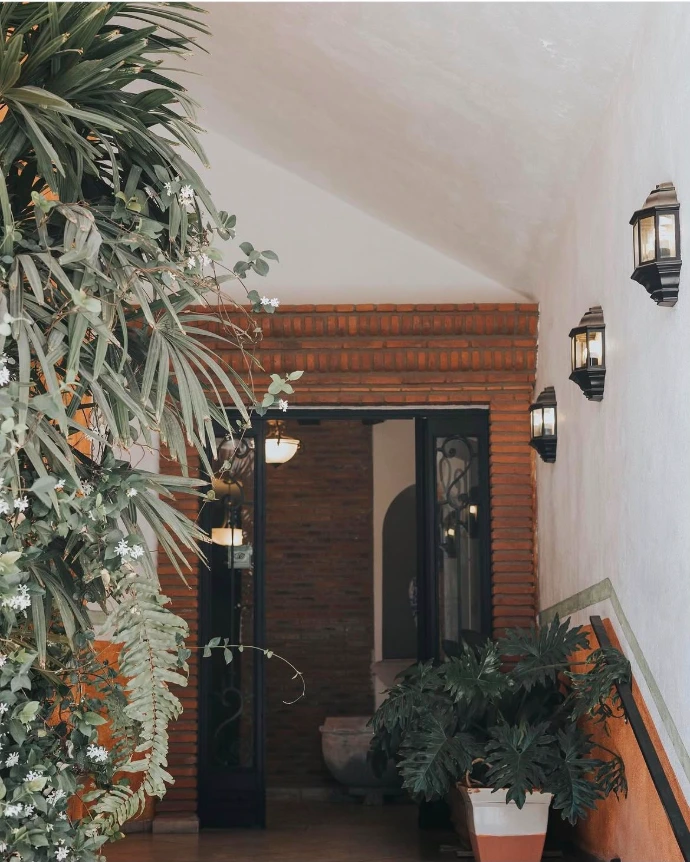Entrada de Restaurant Mirage con muros de ladrillo y plantas